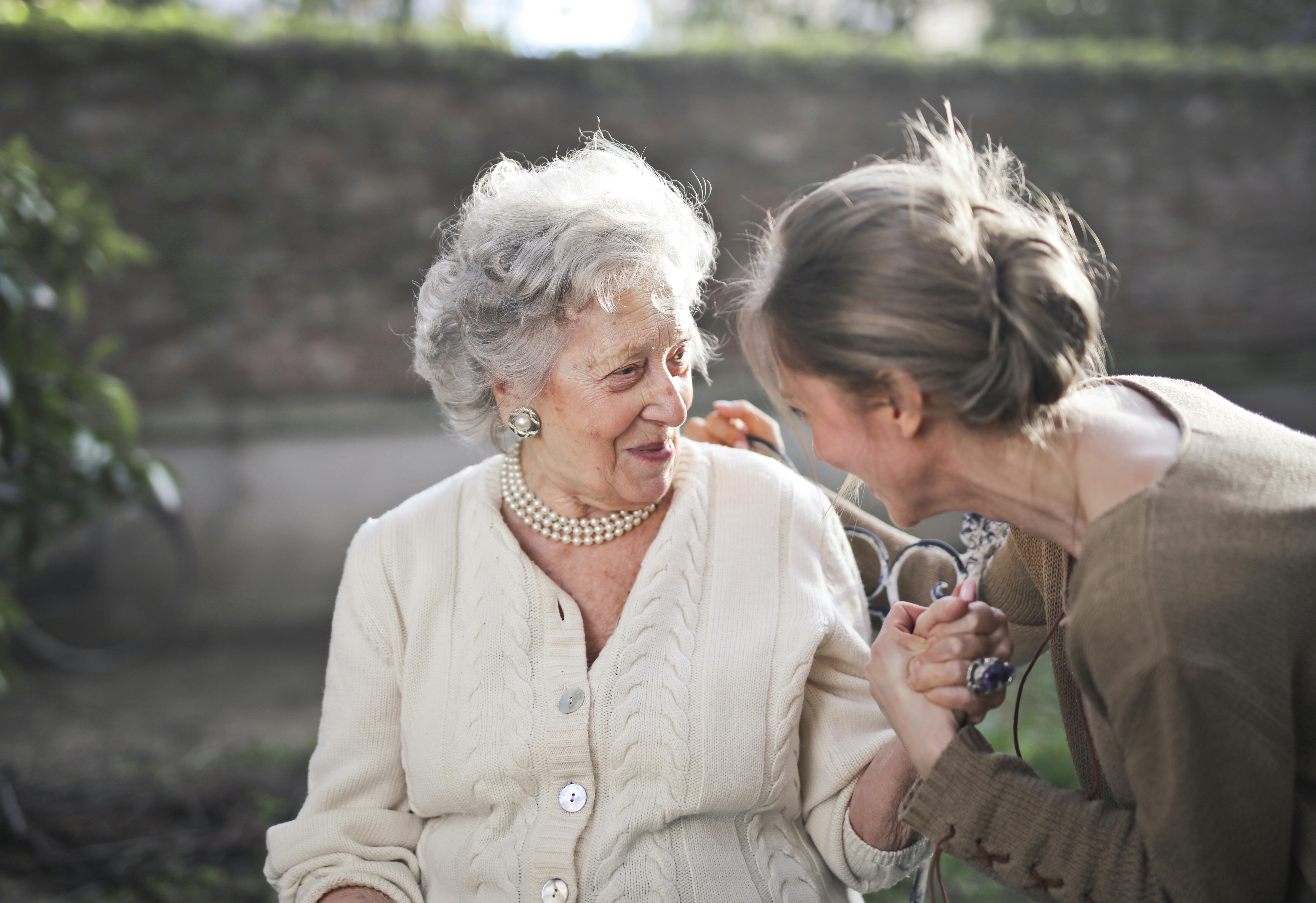 An elderly woman and a younger woman sharing a warm conversation